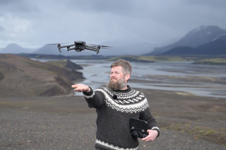 Drone hovering low into a hand-catch above black volcanic sand in the Icelandic Highlands.