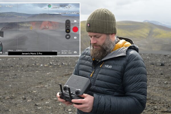 Jeroen holding a drone controller on black volcanic ground, with the live camera feed shown in a panel beside him