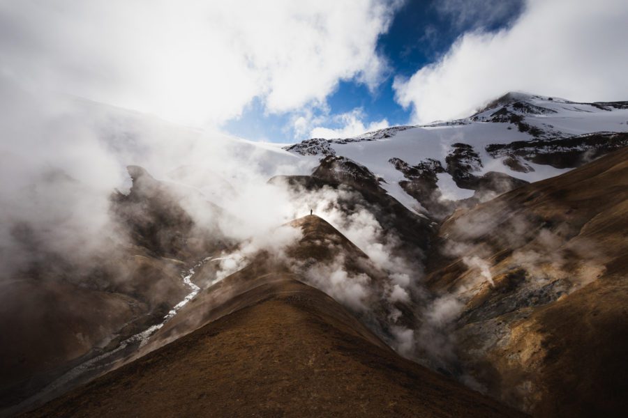 Steaming geothermal valley below snowy peaks at Hveradalir in Kerlingarfjöll, Iceland.