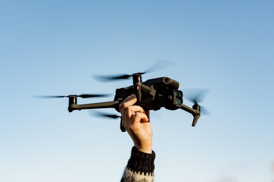Hand holding the DJI Mavic 3 Pro drone against an Icelandic sky at sunset.