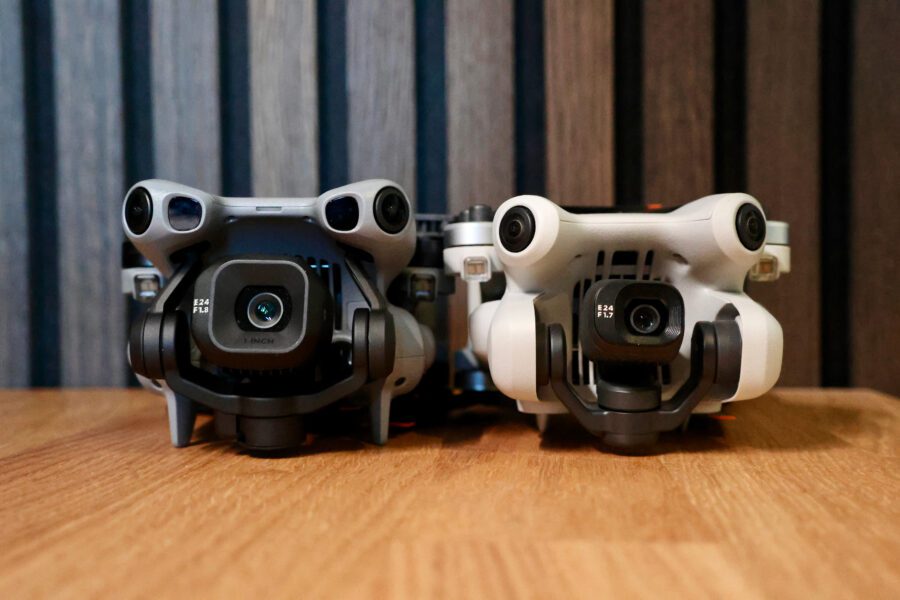 Head-on view of the DJI Mini 5 Pro and Mini 4 Pro lined up, showing the difference in body and lens housing.